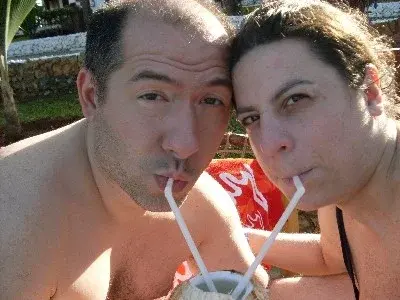 Caterina e Matteo guancia a guancia mentre bevono da una noce di cocco con le cannucce