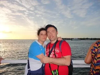 Caterina e Matteo abbracciati sul ponte di una nave, al tramonto sul mare