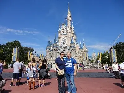Caterina e Matteo davanti al castello di un parco Disney, in una giornata di sole
